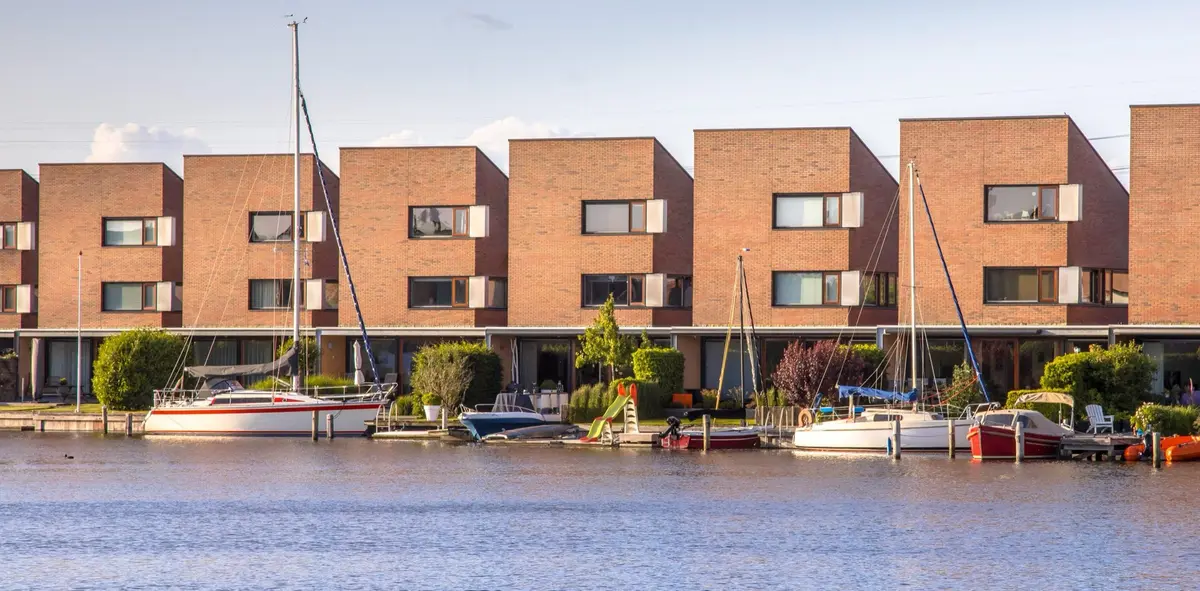 Rij woningen met eigen aanlegplaatsen en zeilboten aan het water